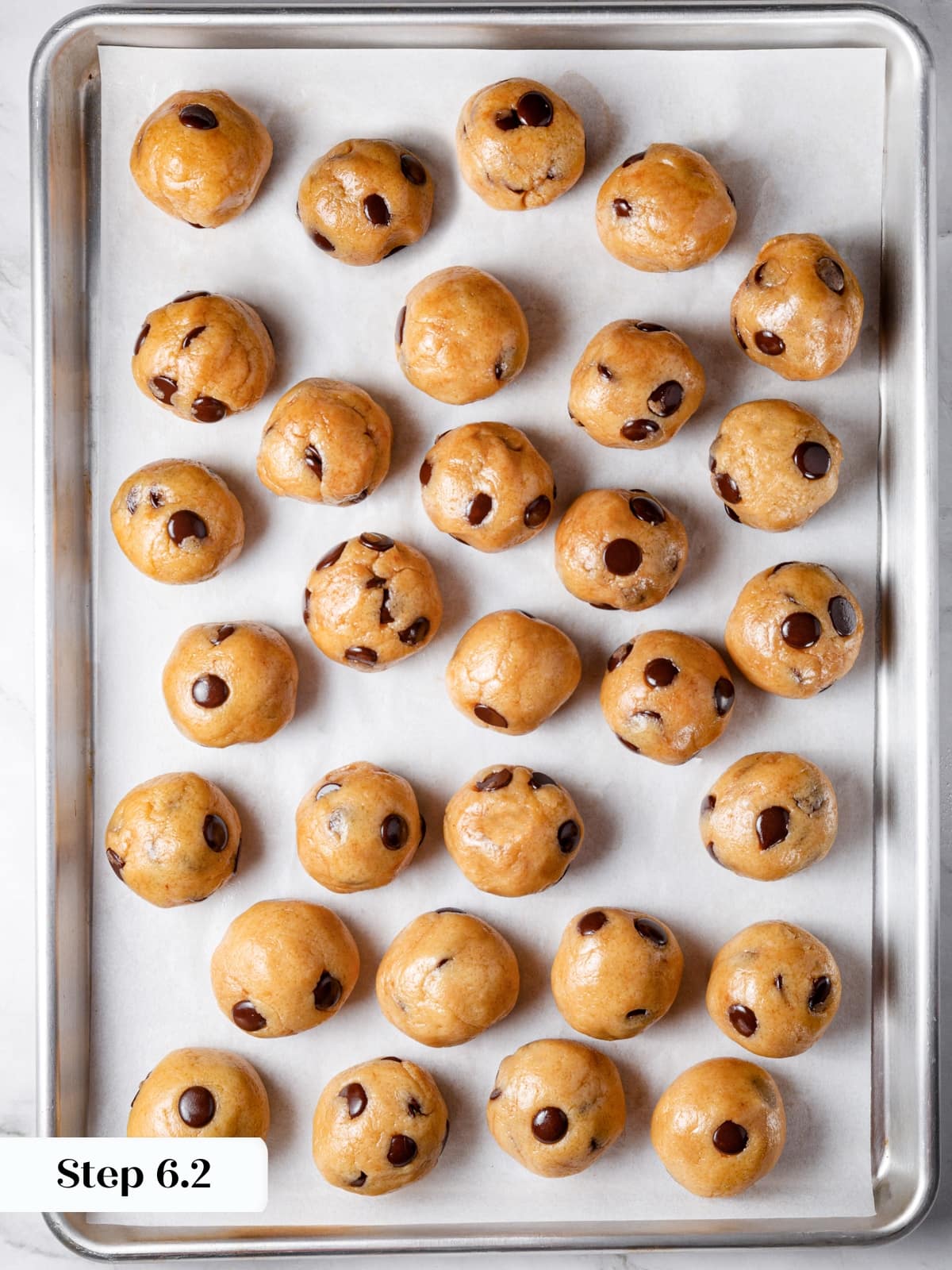 Frozen sourdough cookie dough balls arranged evenly before baking.