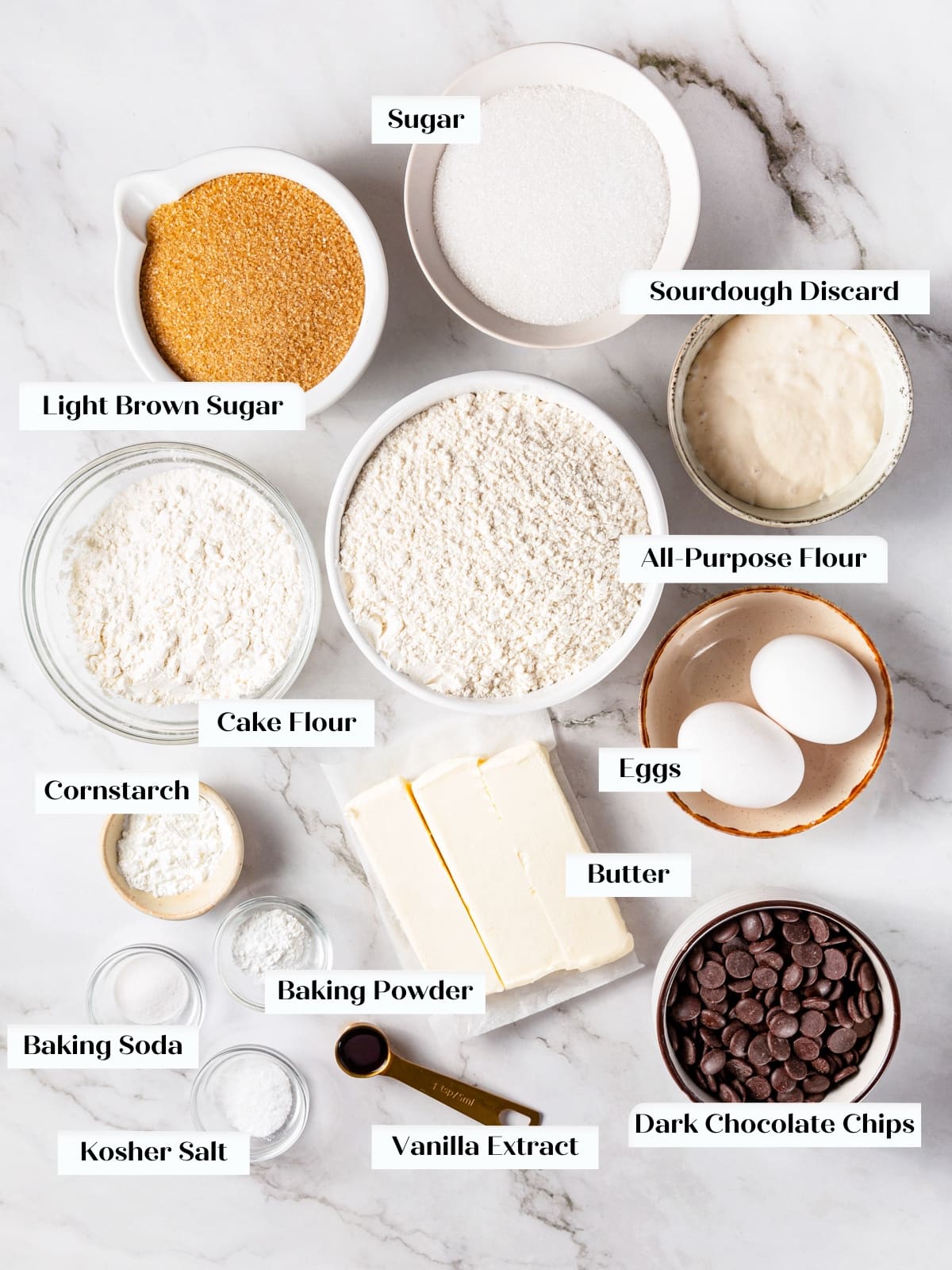 Ingredients for sourdough chocolate chip cookies arranged on kitchen countertop.