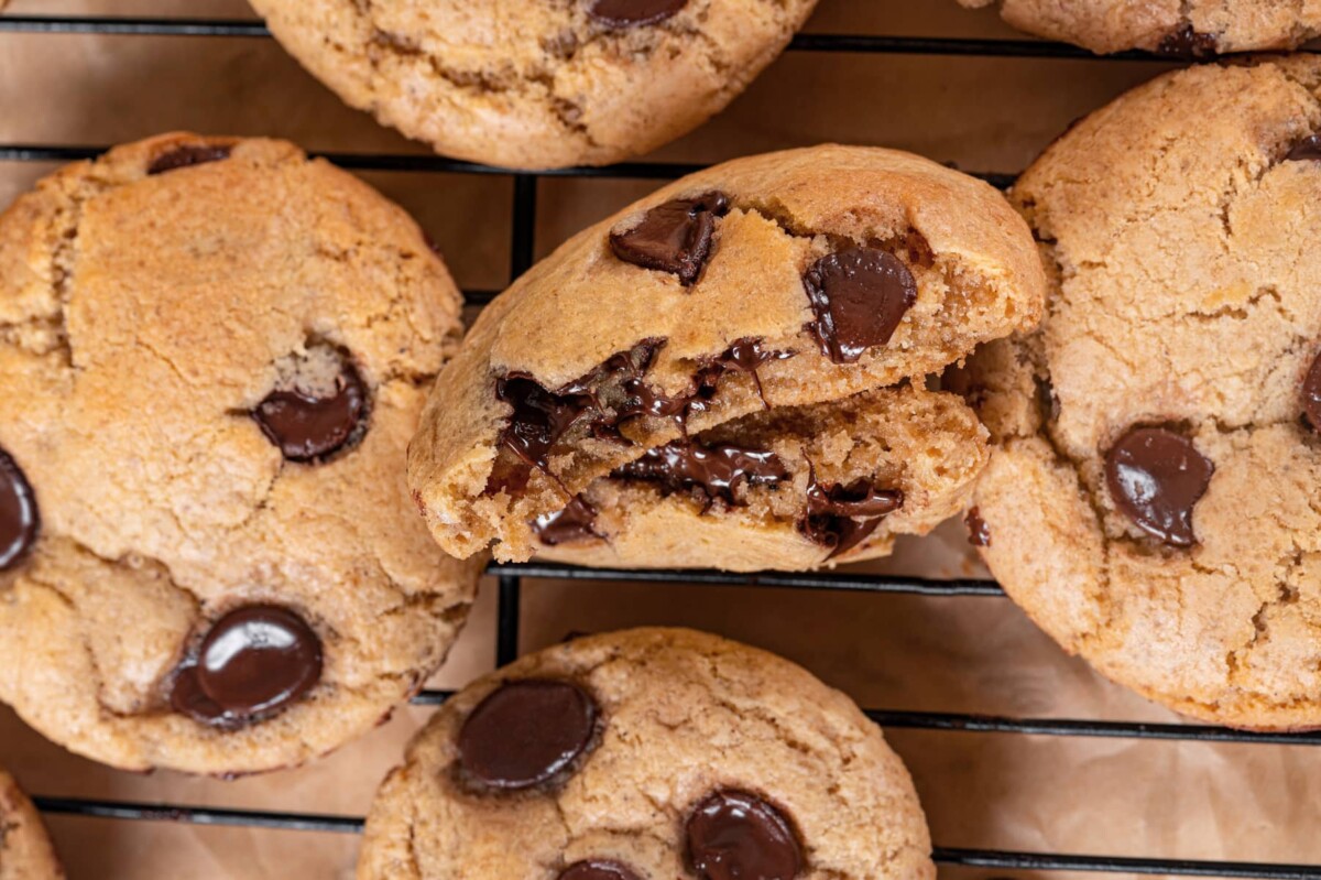Broken cookie showing interior texture beside several whole cookies.