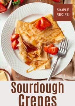 Thin sourdough crêpe layered with fresh strawberries and drizzled maple syrup on a plate.