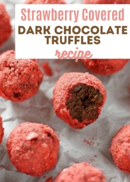 Rich dark chocolate truffles covered in powdered strawberry arranged on parchment.