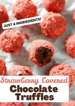 Rich dark chocolate truffles covered in powdered strawberry arranged on parchment.