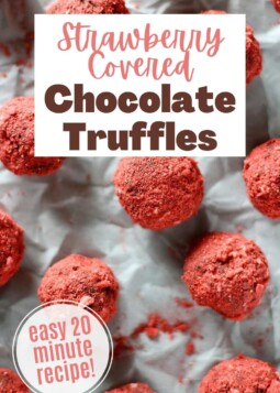 Rich dark chocolate truffles covered in powdered strawberry arranged on parchment.
