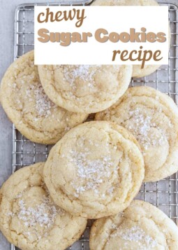 Soft chewy sugar cookies with sparkling sugar topping piled on a wire cooling rack.