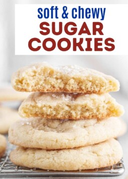 Soft chewy sugar cookies with sparkling sugar topping stacked on a wire cooling rack.