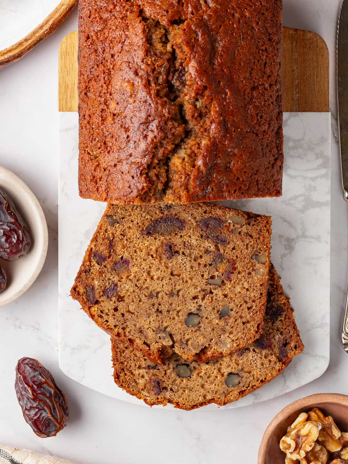 Date nut bread slice showing chopped walnuts throughout the crumb.