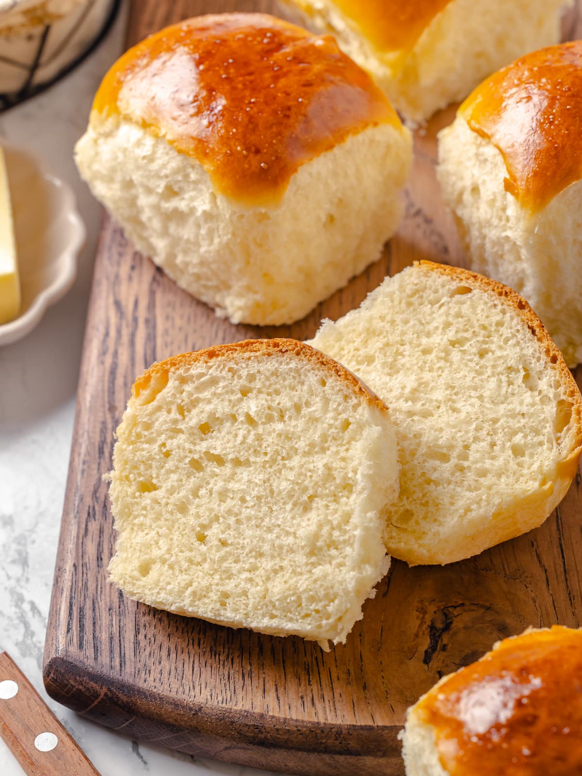 Dinner roll cut in half to show fluffy crumb and soft interior.