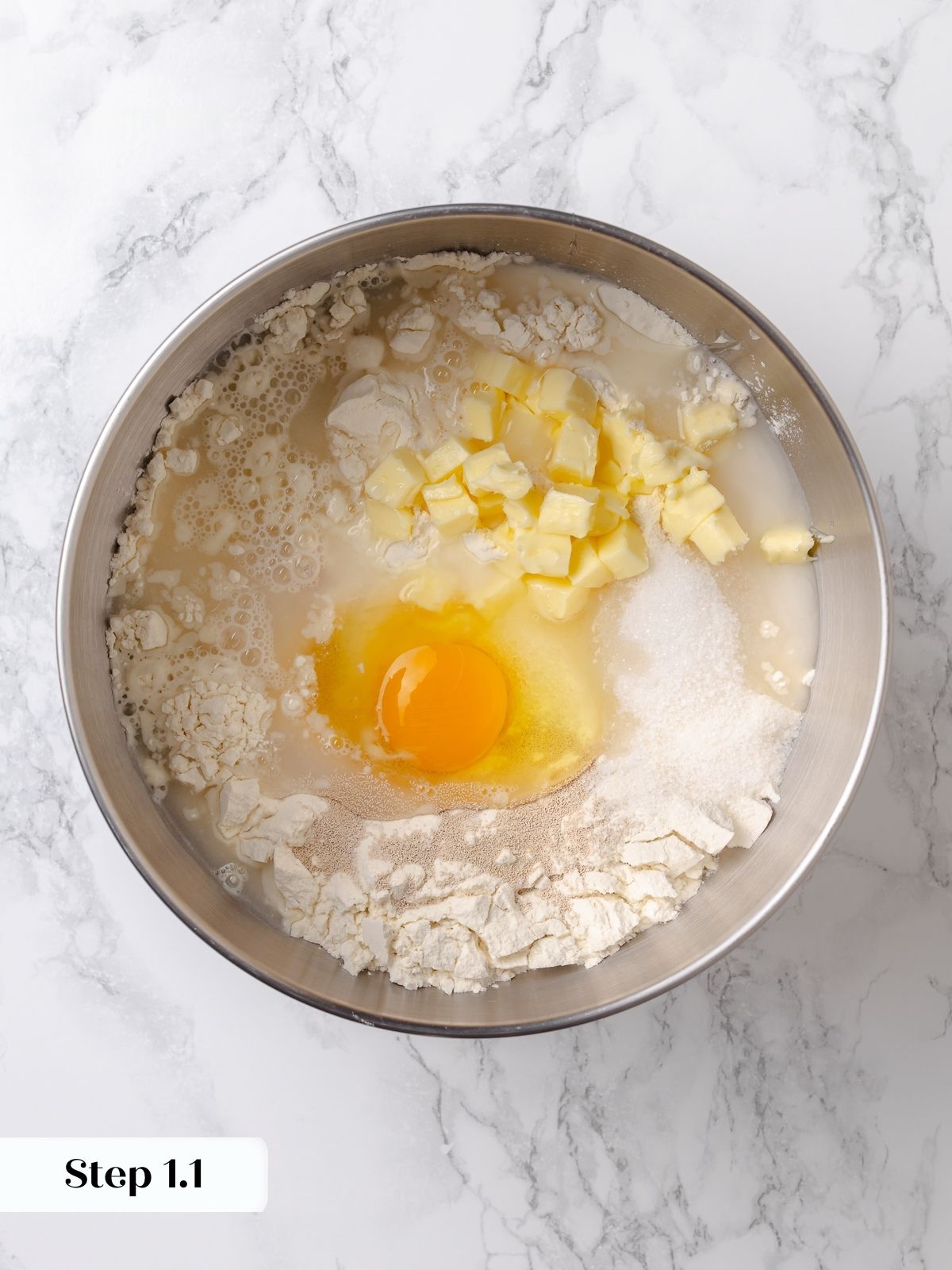 Dinner roll ingredients added together in bowl before mixing begins.