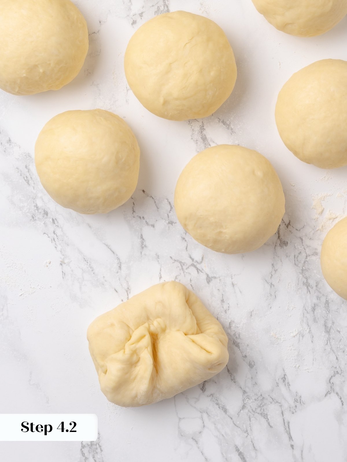 Dough portion folded inward to create surface tension during shaping.
