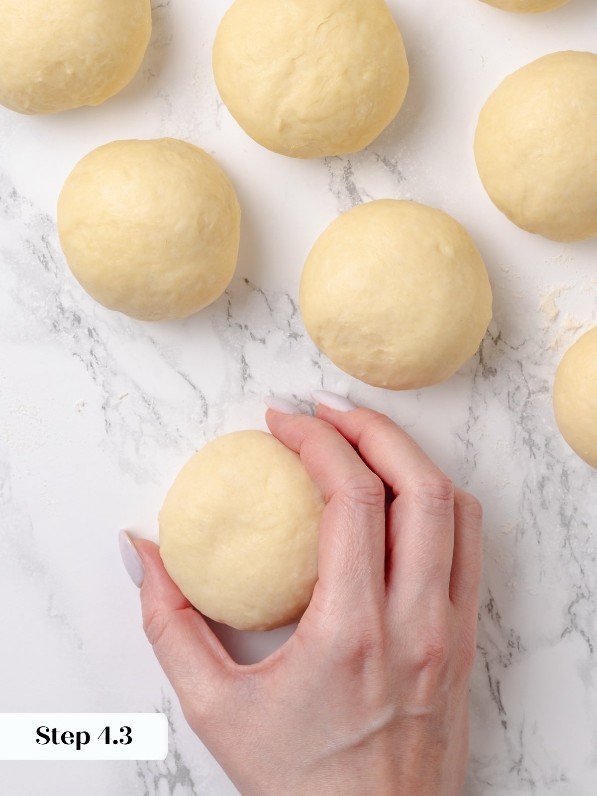 Individual dough portion shaped into a smooth ball by hand.