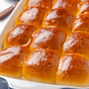 Baked dinner rolls with puffed tops showing full rise and softness.