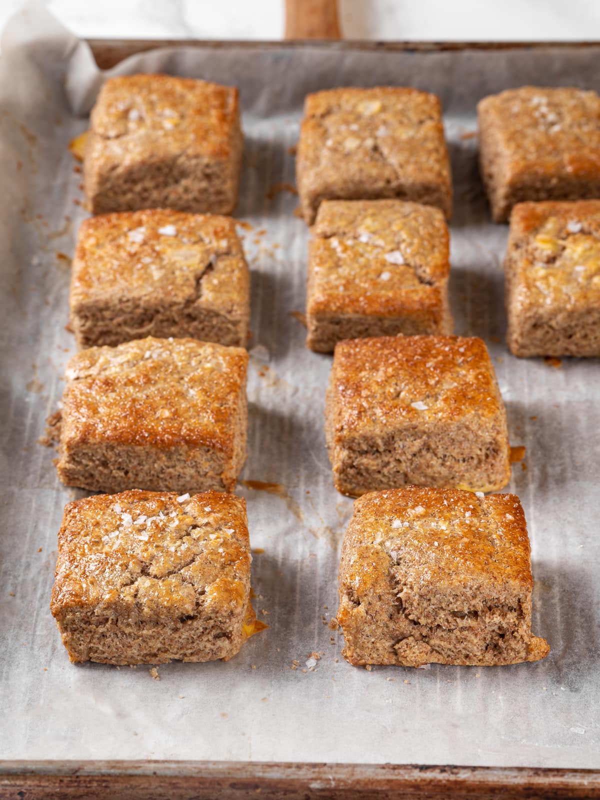 Freshly baked whole wheat biscuits with golden edges and visible flaky layers.