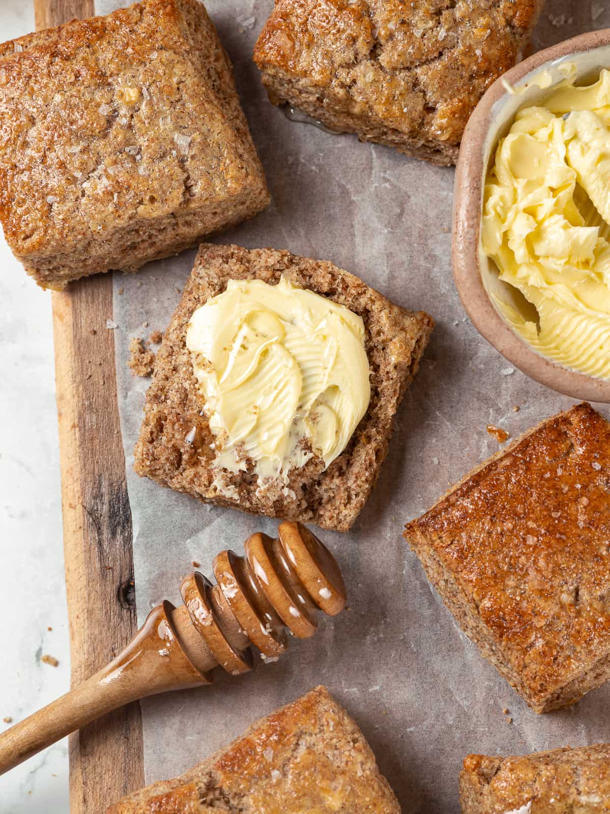 Whole wheat biscuit topped with butter and honey for serving.