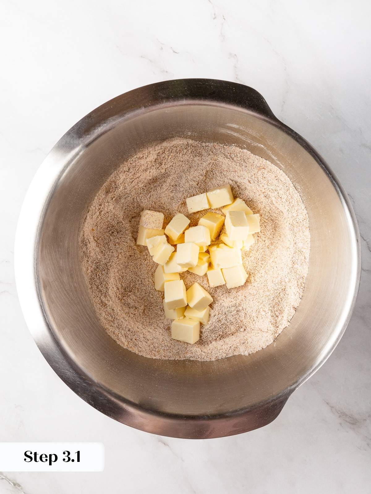 Cold butter cubes added to dry ingredients for biscuit dough.