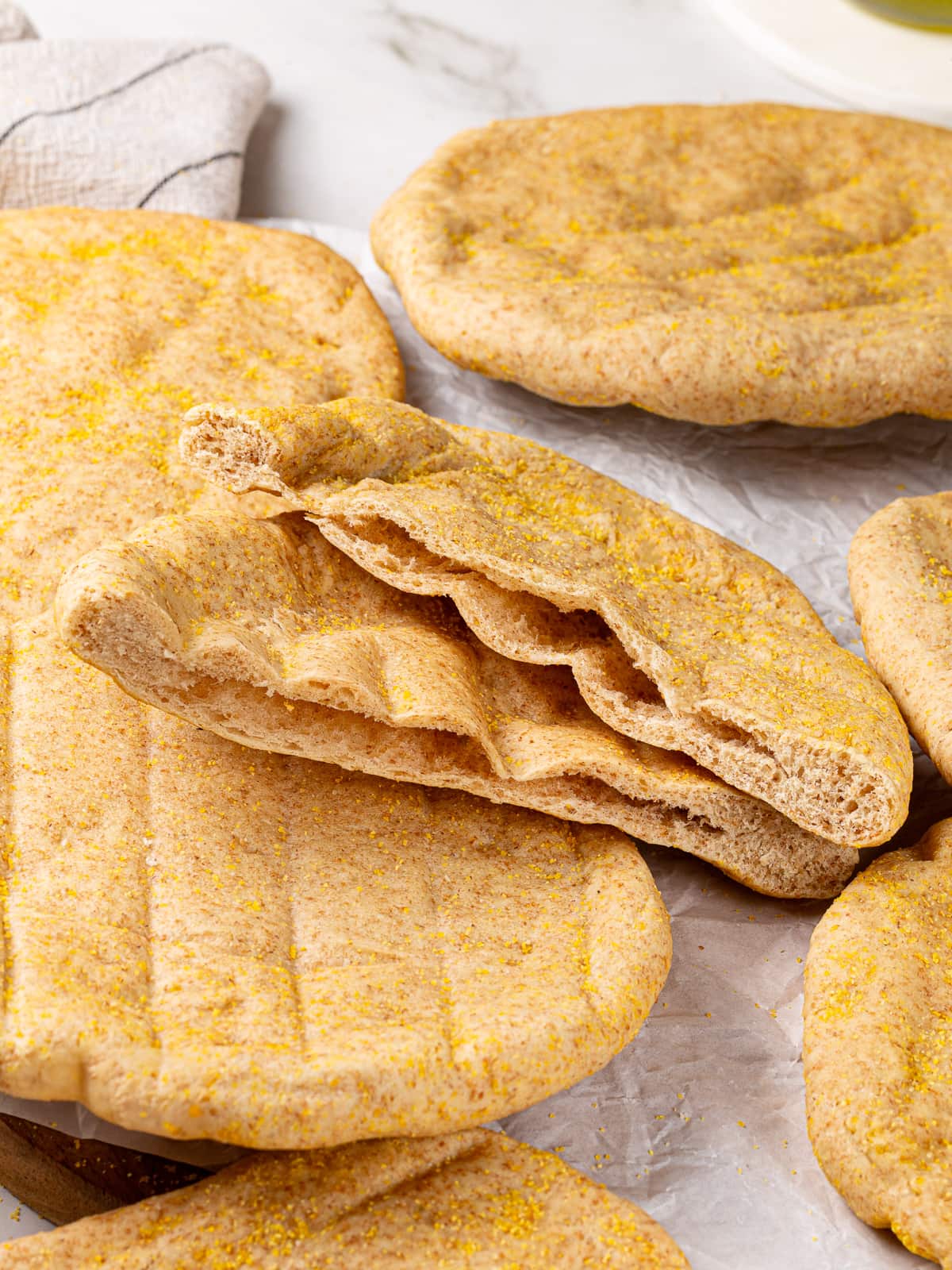 Whole wheat pita cut in half, revealing soft interior pocket.