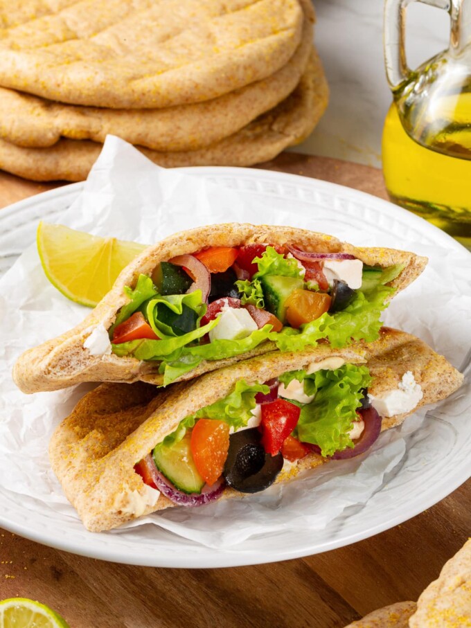 Stuffed whole wheat pita holding vegetables and greens for lunch.