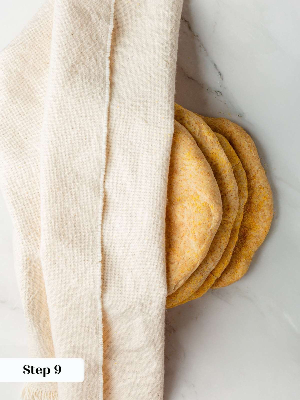 Warm baked pitas wrapped in towel to keep them soft.