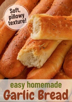 Homemade garlic breadsticks on a baking sheet. Text overlay reads soft pillowy texture.