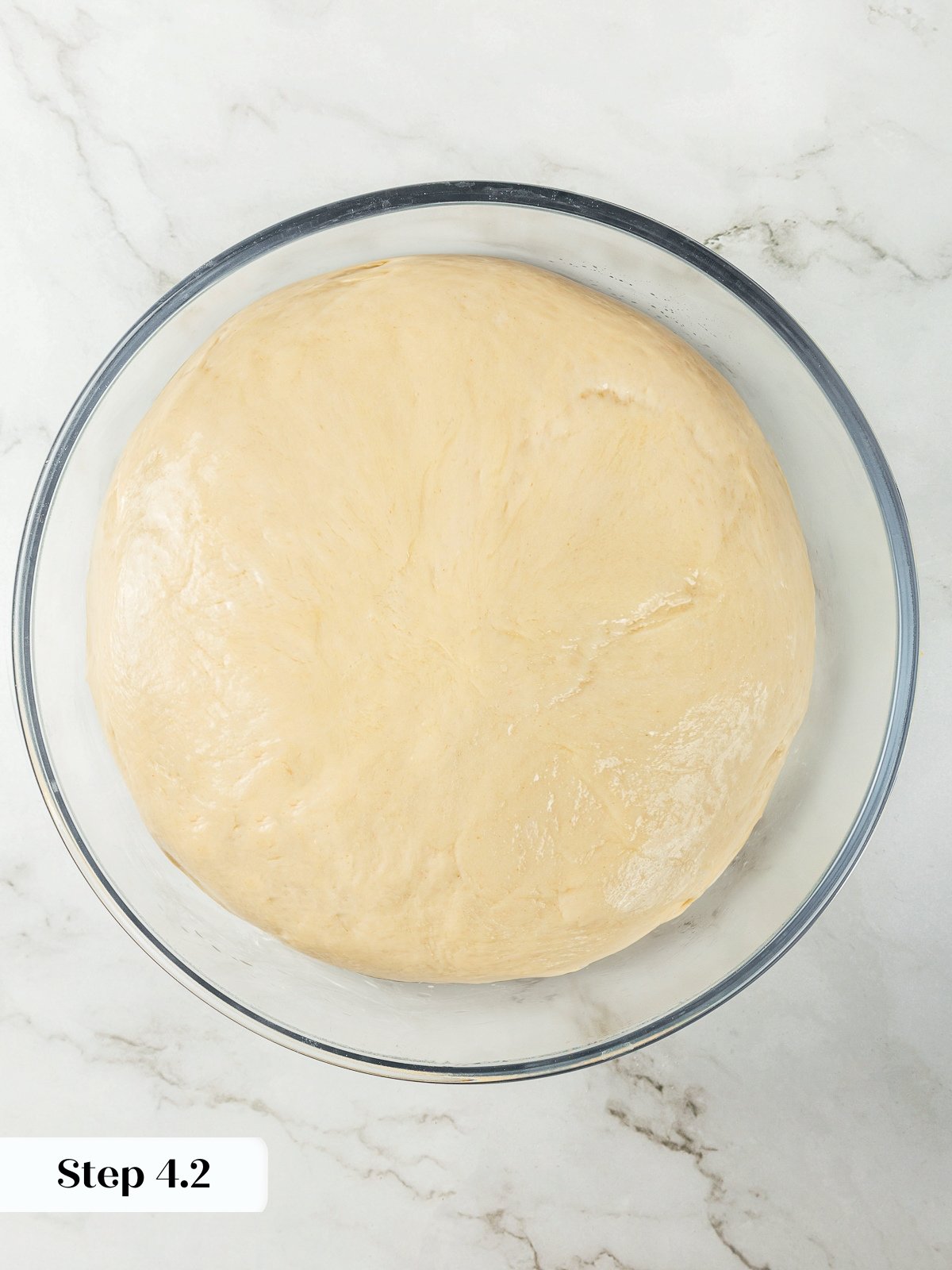 Dough doubled in size after first rise during garlic breadstick preparation.