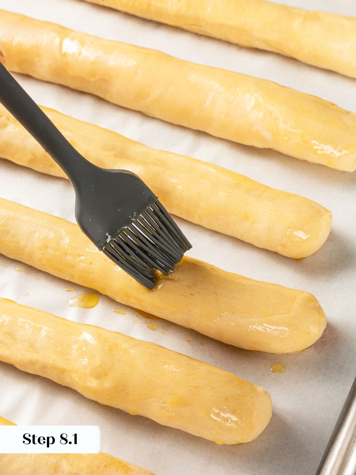Melted butter brushed over breadsticks before baking for golden crust.