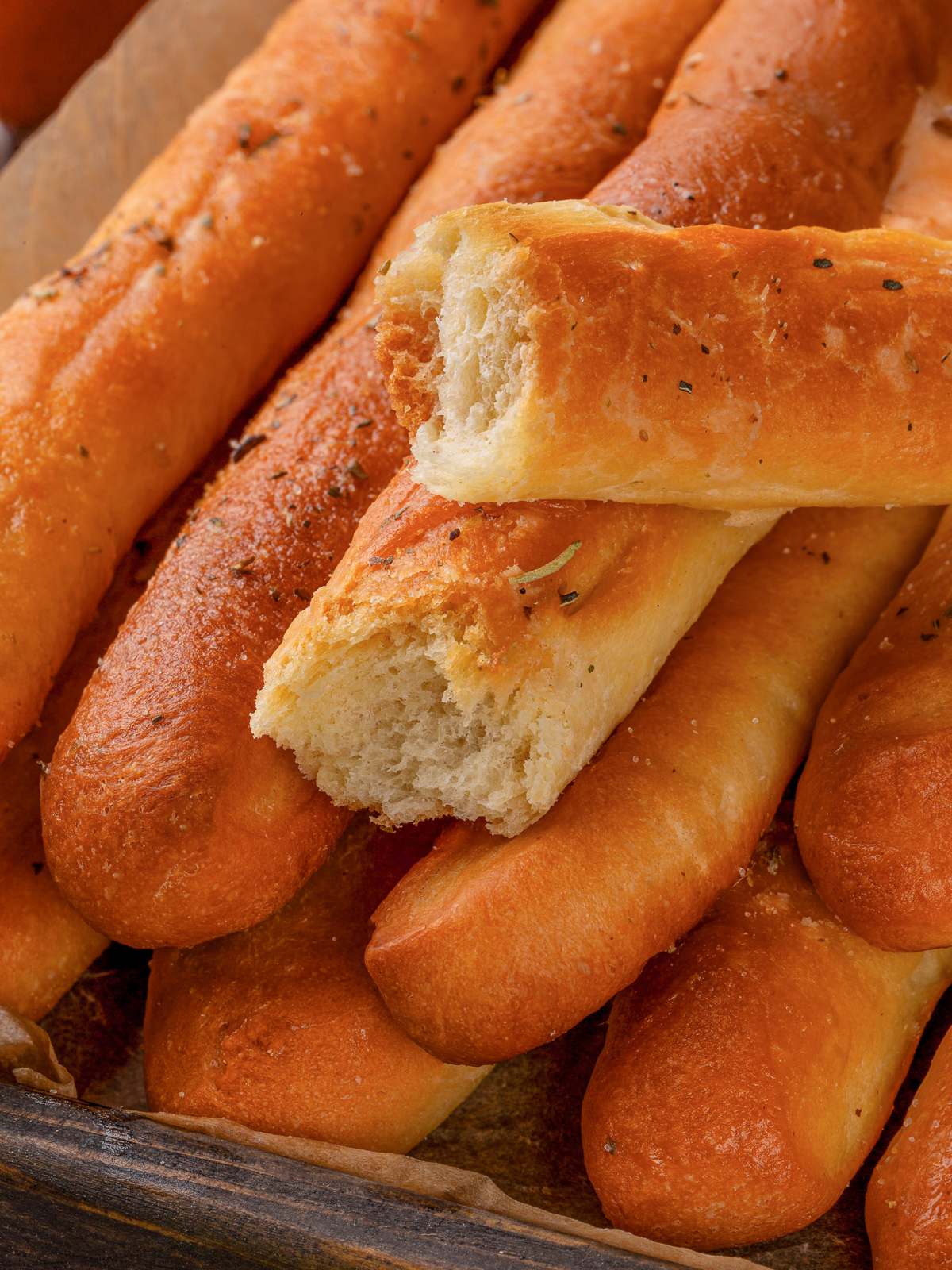 Garlic breadstick pulled apart revealing soft fluffy interior and tender crumb.