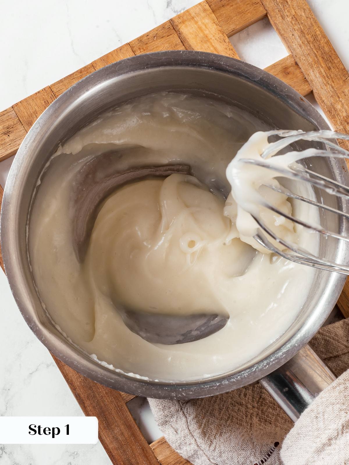 Tangzhong paste cooking in saucepan while whisking flour milk and water together.