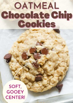 Golden brown oatmeal chocolate chip cookie on parchment paper. Text overlay reads soft gooey center.