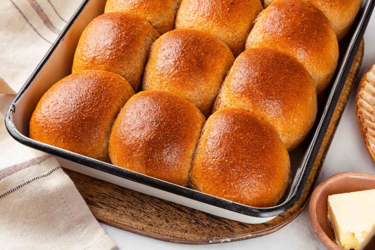 Whole wheat dinner rolls cooling after baking with golden tops.