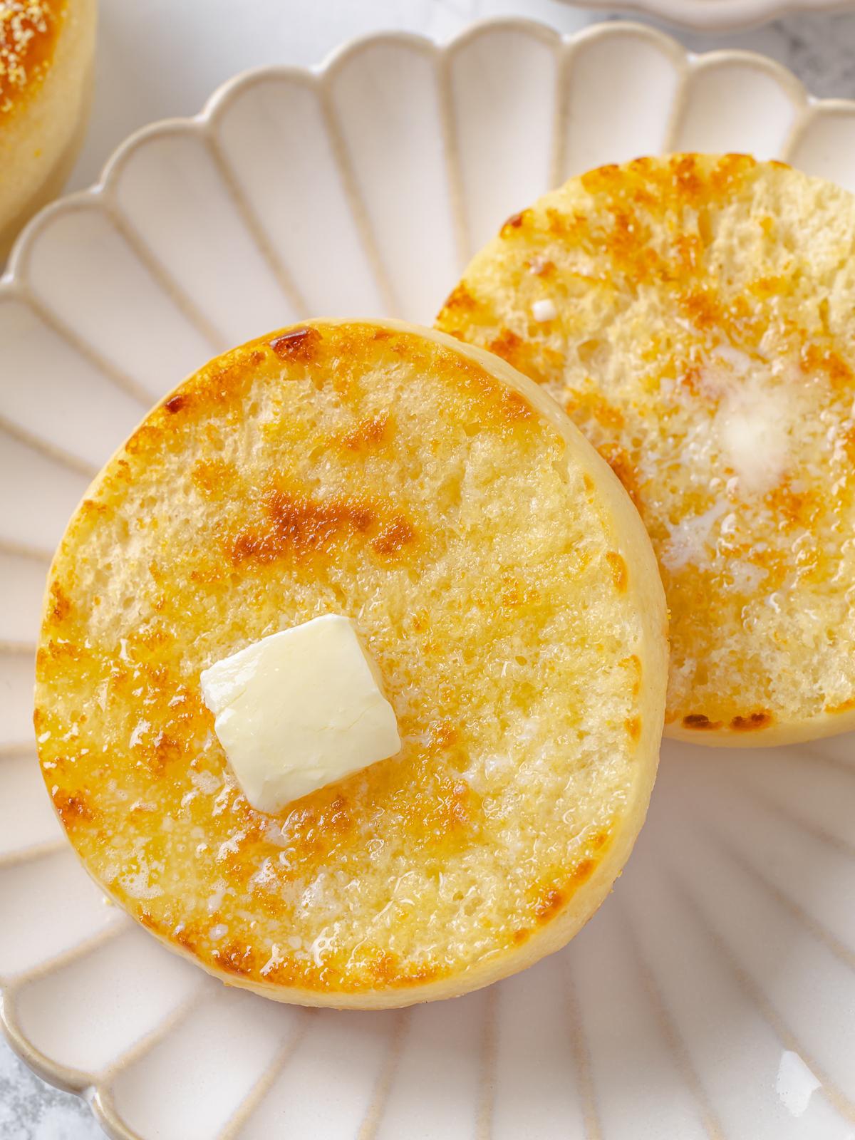 Square of butter placed on warm muffin beginning to soften and melt into surface.