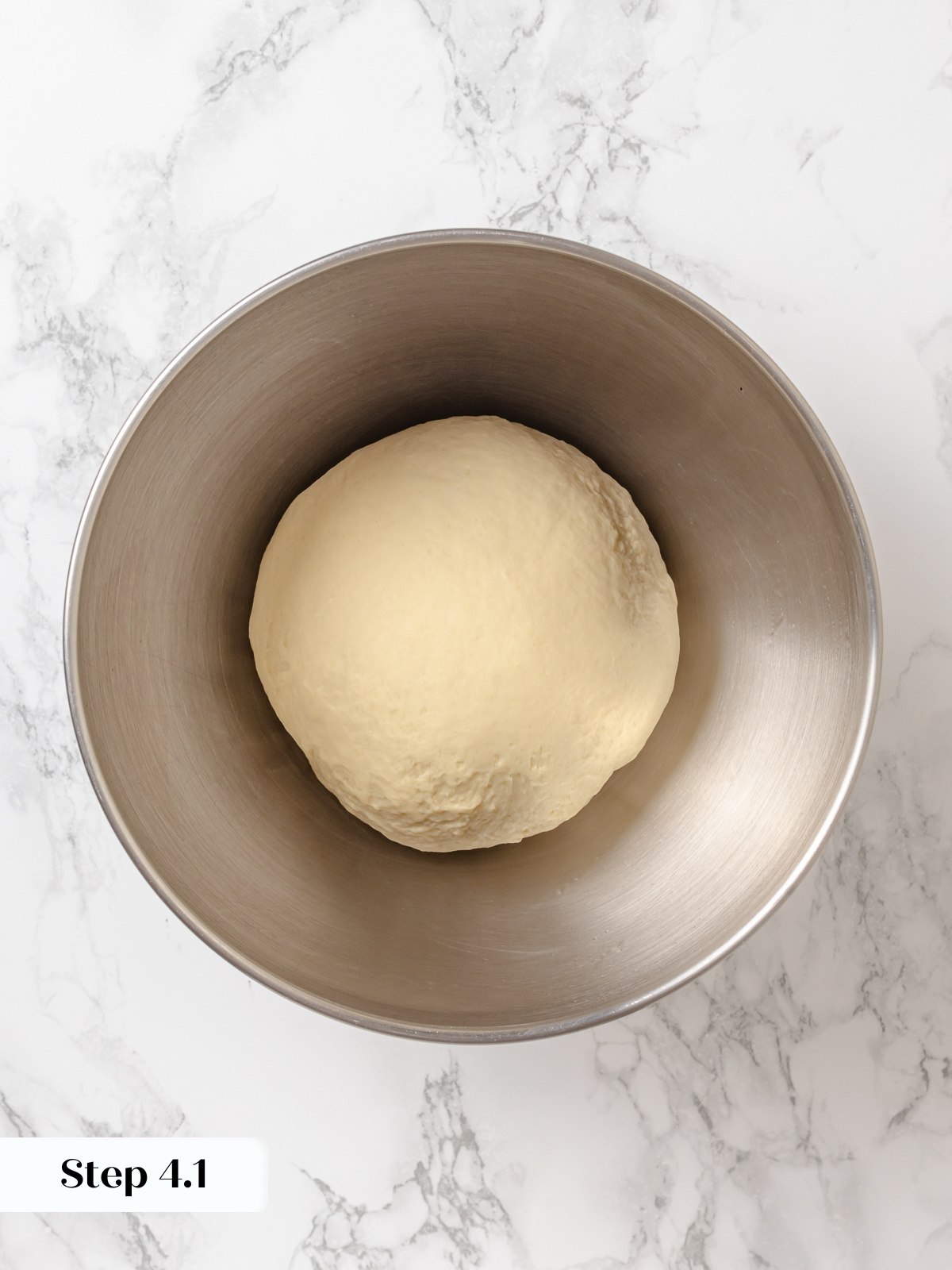 Dough resting in bowl before proofing with smooth surface and slightly elastic texture.