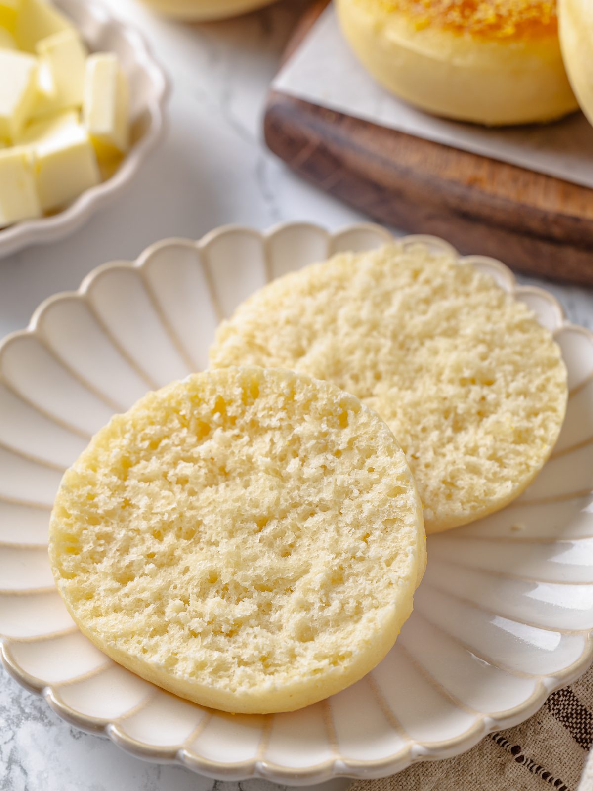 Split English muffin showing soft interior before toasting with pale crumb and visible air pockets.