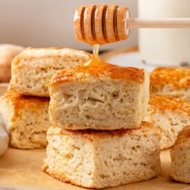 Two sourdough biscuits stacked showing golden crust and soft interior layers.