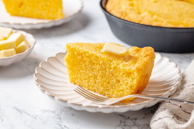 Single piece of sourdough cornbread showing fluffy interior and golden, crisp outer edges.