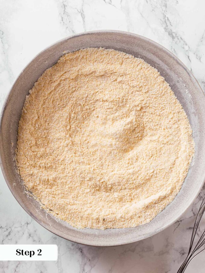 Dry ingredients whisked together in bowl combining flour, cornmeal, sugar, and leavening.