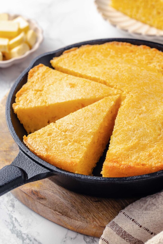 Cornbread cut into wedges revealing soft interior and evenly baked crumb throughout.