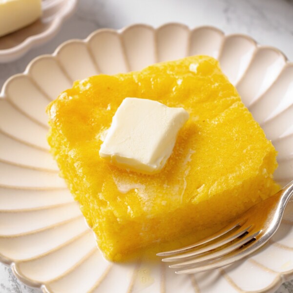 Portion of spoon bread served on plate, showing soft, spoonable texture and light structure.