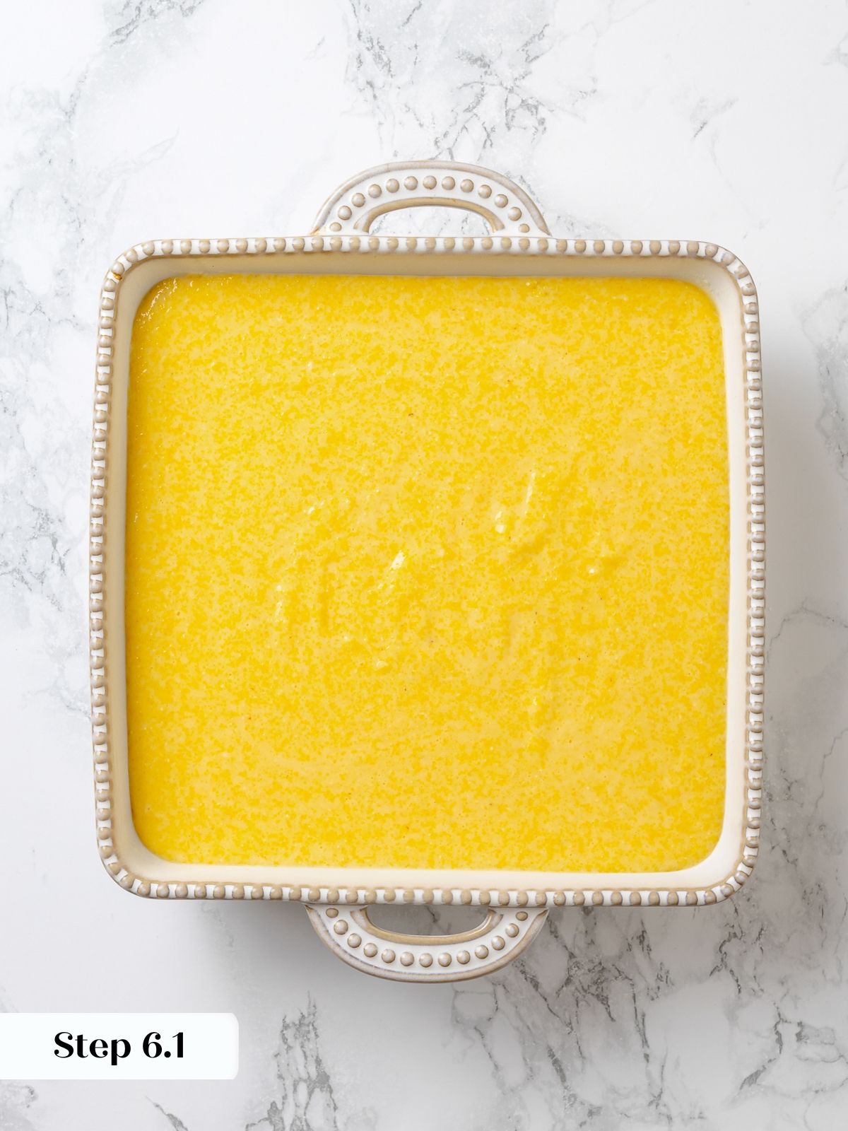 Spoon bread batter poured into buttered baking dish before baking, smooth and slightly thick.