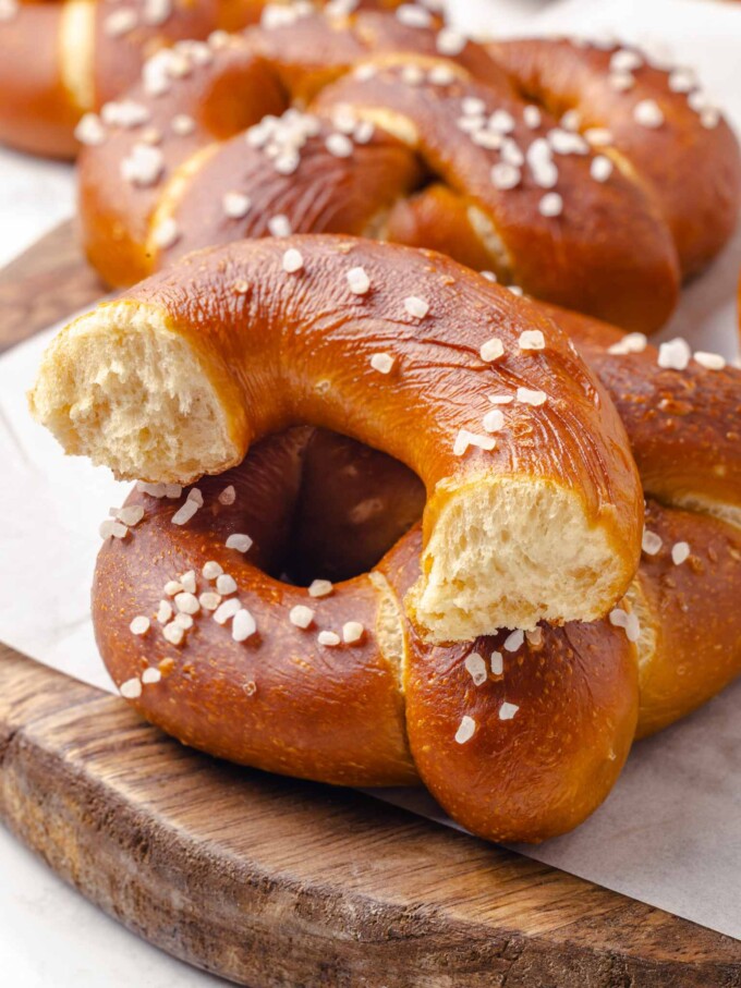Salted pretzel torn open to expose soft pale crumb contrasting with the deep mahogany crust.