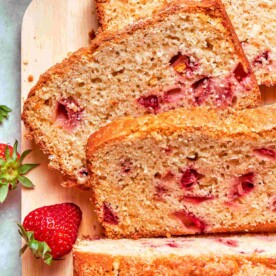 Square crop of strawberry bread slices revealing tender crumb and bright pink berry pieces.