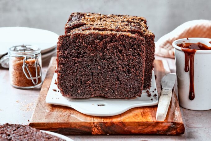 Wide framing shows the chocolate bread alongside its slices, ready for a cozy afternoon with coffee.