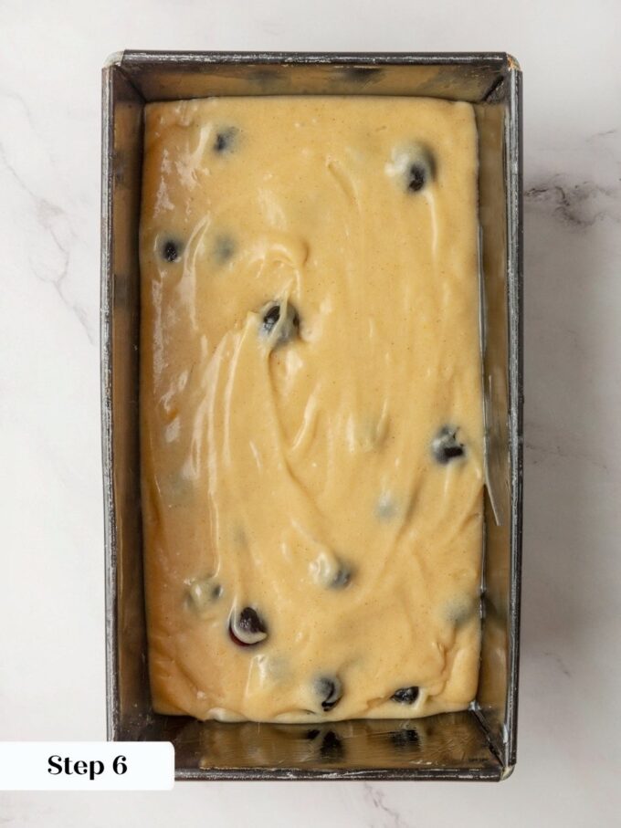 Berries visible throughout the raw batter preview how evenly they suspend in baked blueberry bread.