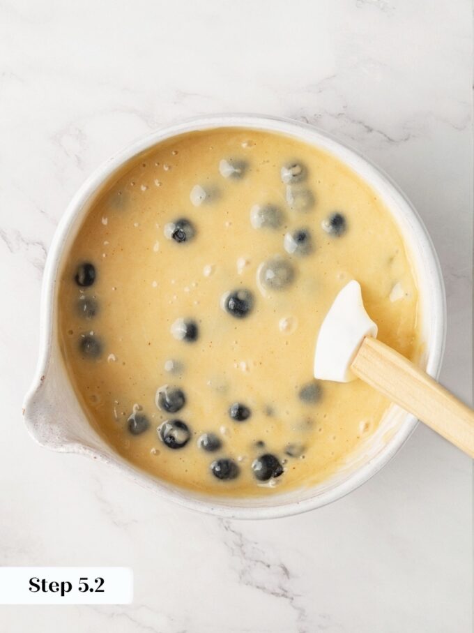 Folding flour-dusted berries in last is what keeps blueberry bread fruit from sinking to the bottom.