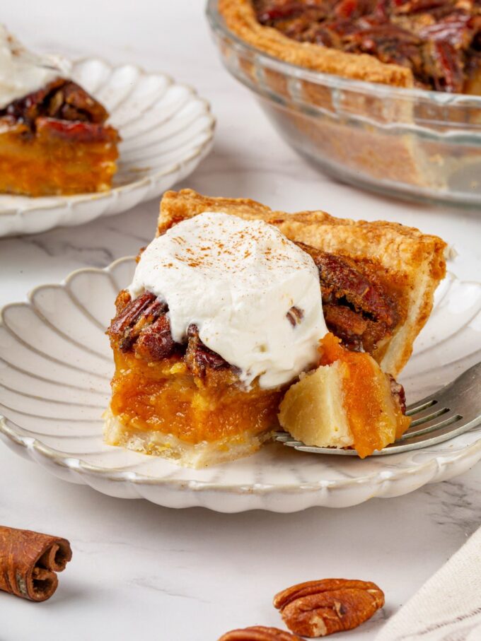The forkful shows how a pumpkin pecan pie holds a clean line between pumpkin and pecan.