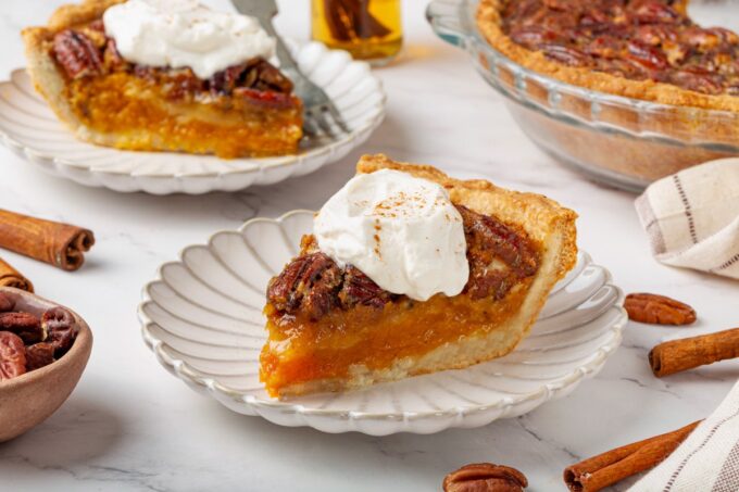 Its slice profile shows both pumpkin pecan pie layers, the creamy base beneath the nutty top.