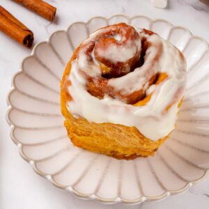 Plated and iced, sweet potato cinnamon rolls carry a tang from the cream cheese frosting.