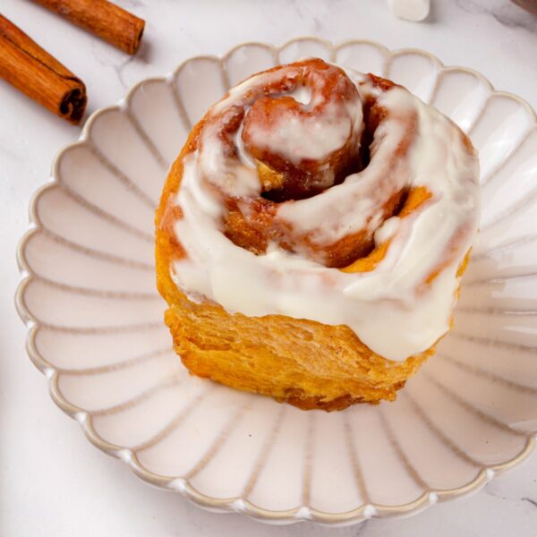 Plated and iced, sweet potato cinnamon rolls carry a tang from the cream cheese frosting.