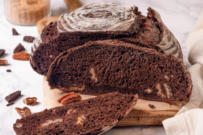 Alternate angle of chocolate sourdough bread shows open crumb pockets and the banneton spiral crust together.