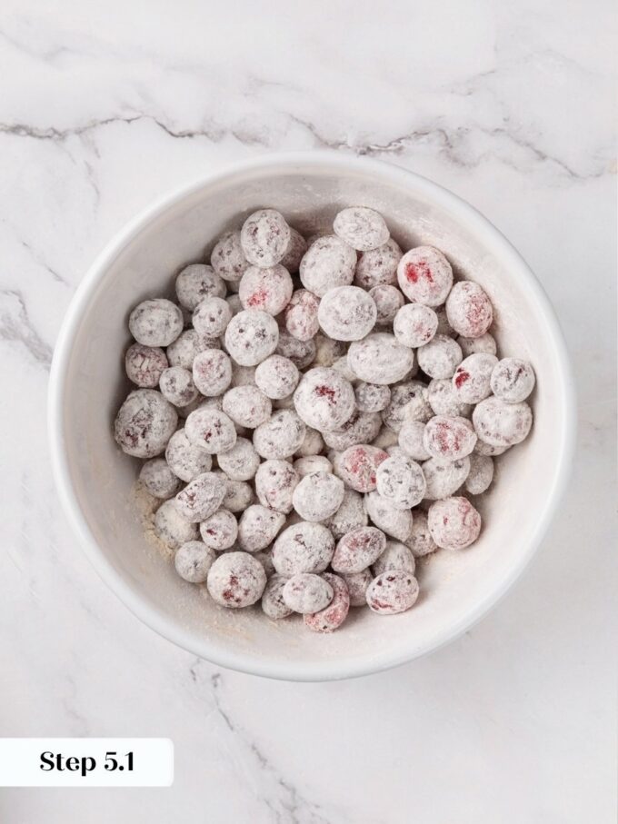 The flour coating suspends fruit through the cranberry bread rather than letting it sink downward.