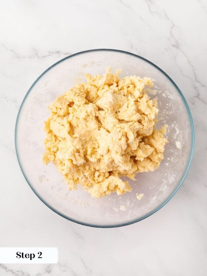 Adding water one spoonful at a time keeps homemade apple pie dough tender.