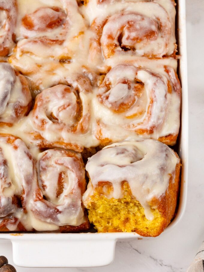 Even still in the dish, pumpkin cinnamon rolls show how far the pumpkin color reaches.